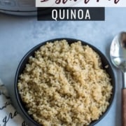 A black bowl with fresh and fluffy quinoa in the middle, a silver spoon with a wooden handle to the right, and an Instant Pot pressure cooker in the back left and the words Instant Pot Quinoa in the top right corner.