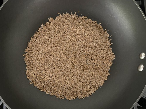 A heavy bottom pan with cumin seeds while they roast.