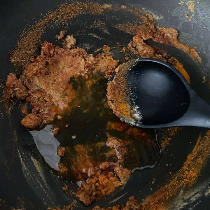 Oil added to the spices in the wok.