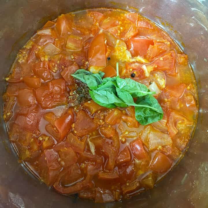 Basil and seasoning on top of the cooked tomatoes.