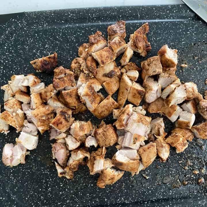 Chopped chipotle grilled chicken on a black cutting board