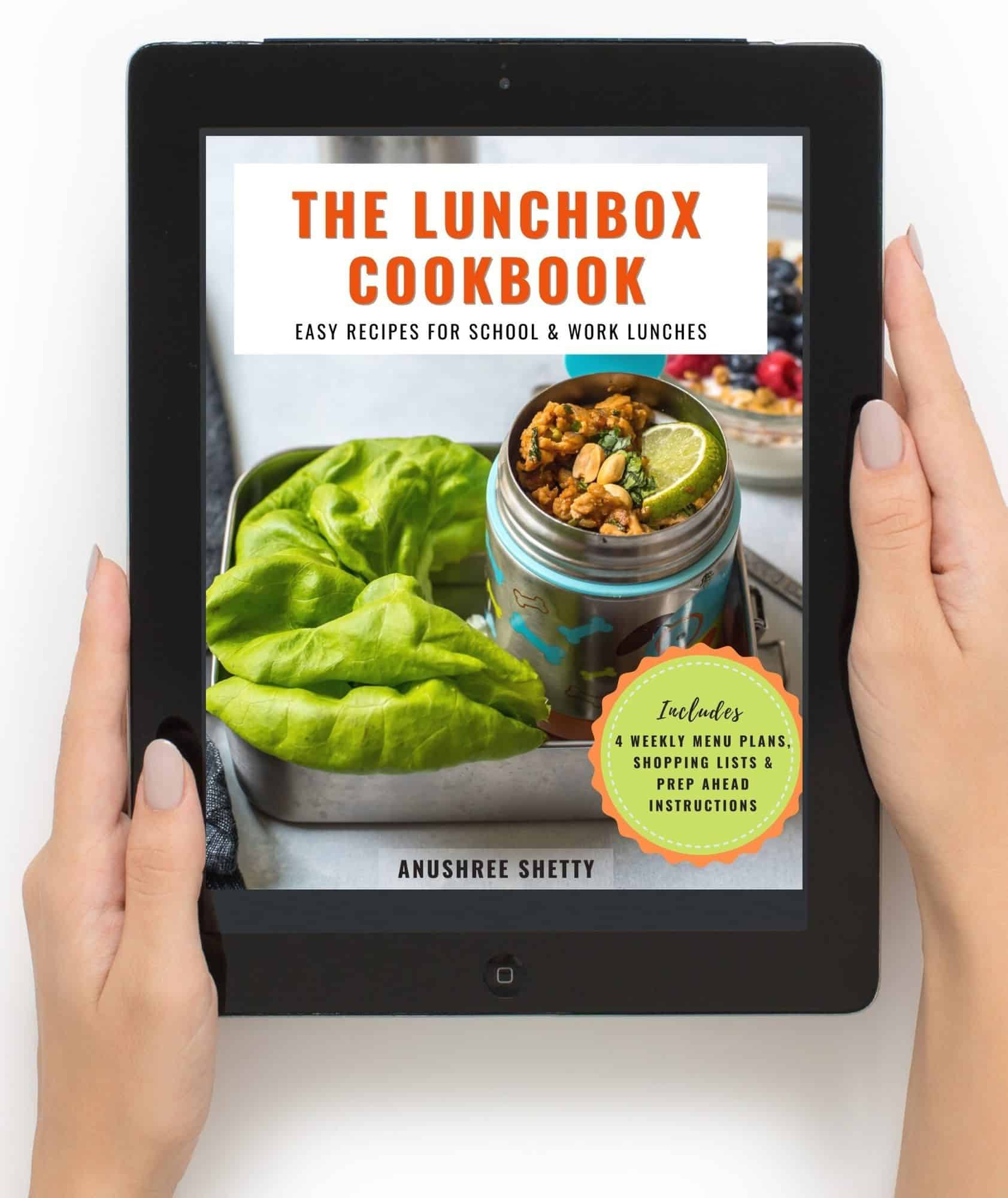 The Lunchbox cookbook eBook is opened on an iPad which is hand-held.