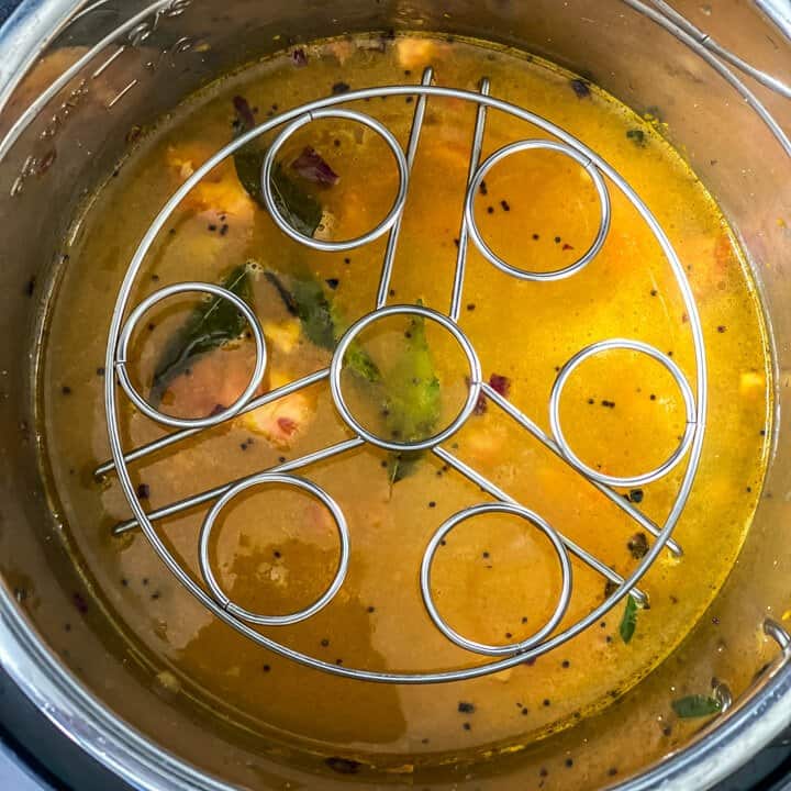 Trivet placed over uncooked dal