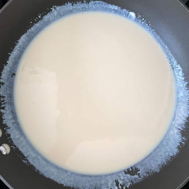 Milk boiling in a black pan