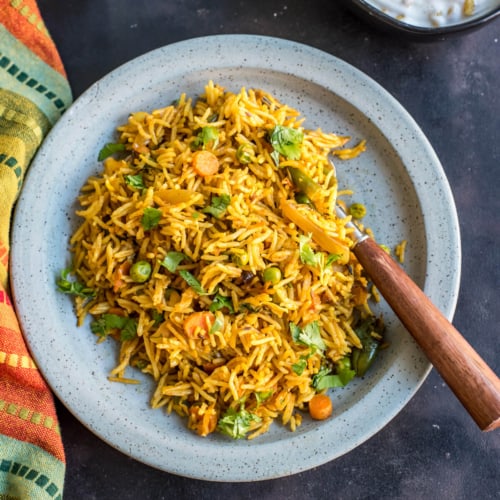 a blue plate filled with this tua pulao recipe