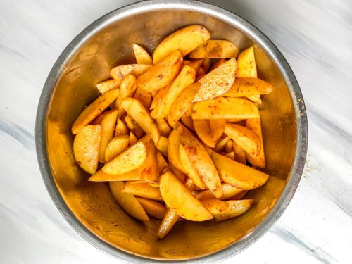 Spiced potato wedges in a steel bowl