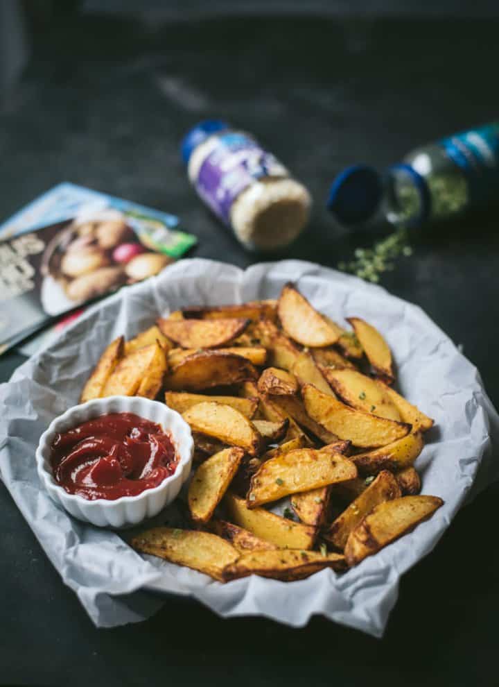 Air-fried potato wedges served on parchment paper with ketchup