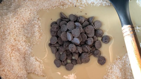 Condensed milk and chocolate chips added to coconut