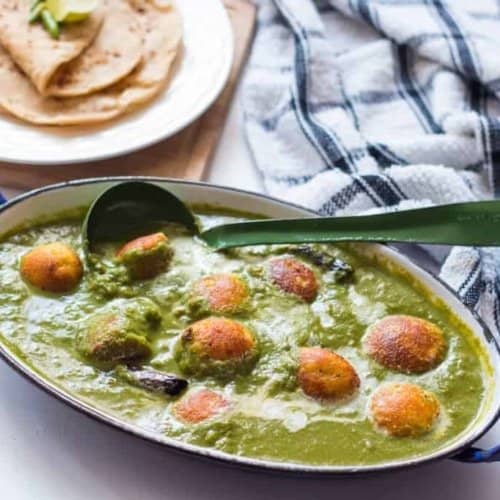 Palak Paneer kofta served in a casserole with a ladle