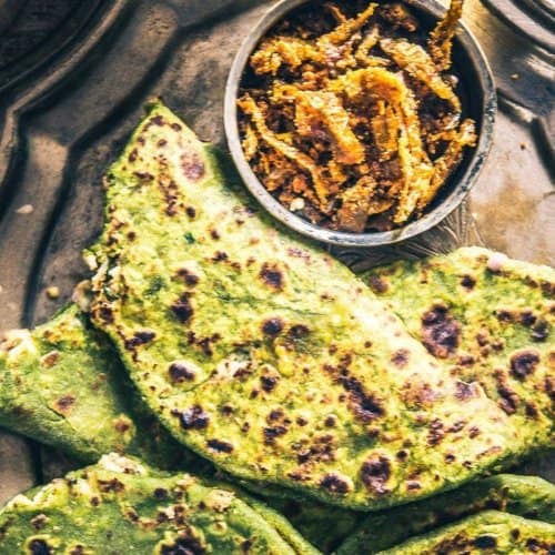 Palak paratha served in a pewter plate
