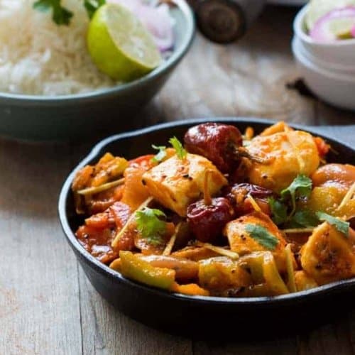 Achari paneer served with a side of rice and red onions