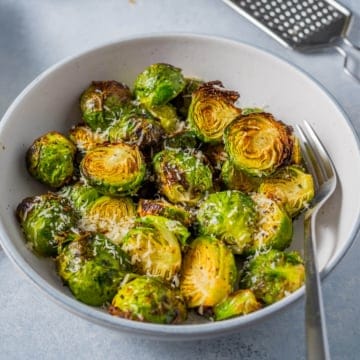 Crispy Air Fryer Brussels Sprouts in a white bowl with a fork
