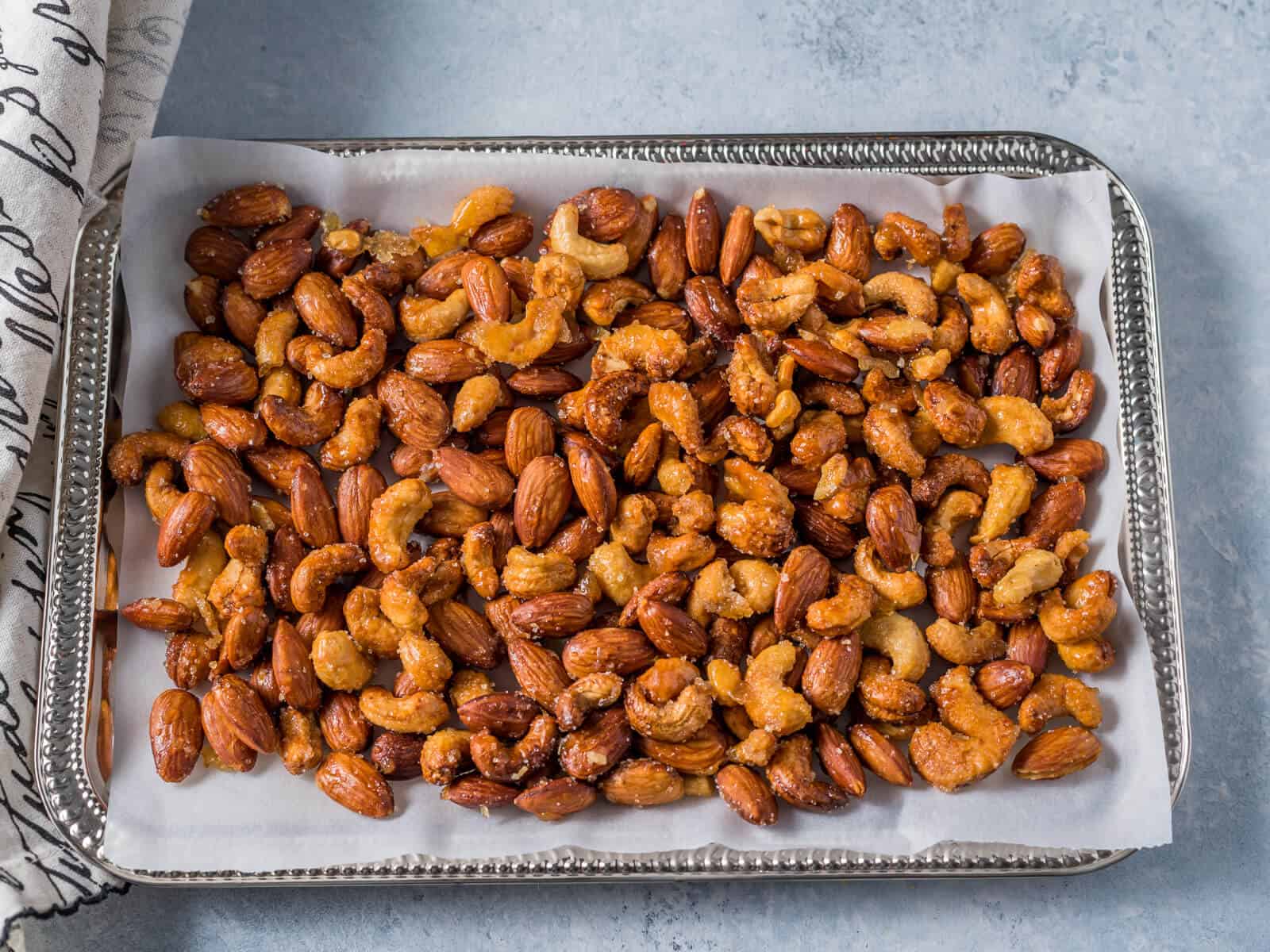 Honey roasted nuts on a parchment paper lined tray