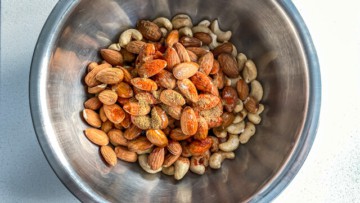 Nuts mixed with spices in a steel bowl