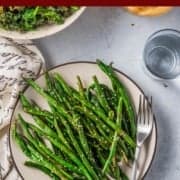 Air Fryer Green Beans (Asian-Style) in an air fryer basket lined with parchment paper with a fork pinterest image