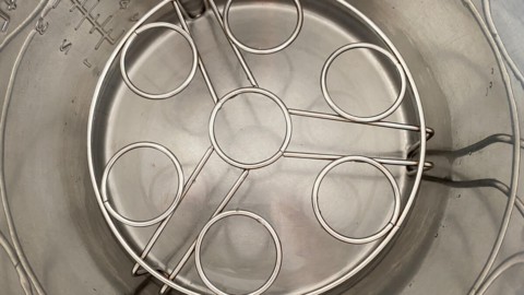 A trivet inside of the inner pot of an Instant Pot, with water under it.