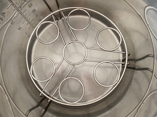 A trivet inside of the inner pot of an Instant Pot, with water under it.