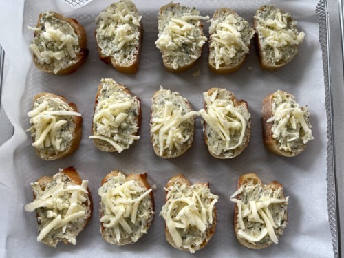 Baguette slices that have been spread with garlic butter and topped with cheese.