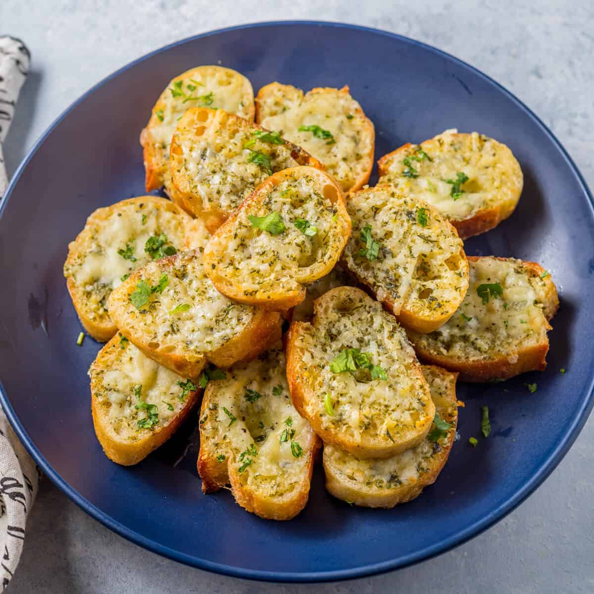 A plate of garlic bread made with a baguette.