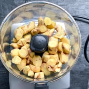 Adding chopped ginger to a food processor.