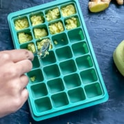 Homemade ginger paste being added to a silicone ice cube tray.