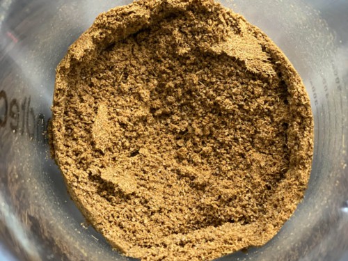 A fine powder of cumin inside the jug of a blender.