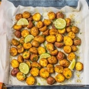 A tray of baby potatoes on a tray lined with parchment paper.