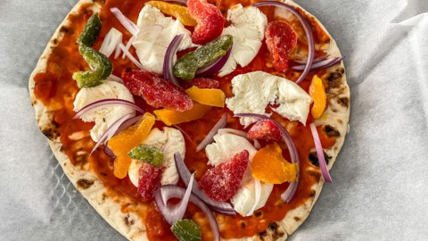 Naan bread topped with sauce, veggies, and fresh mozzarella.