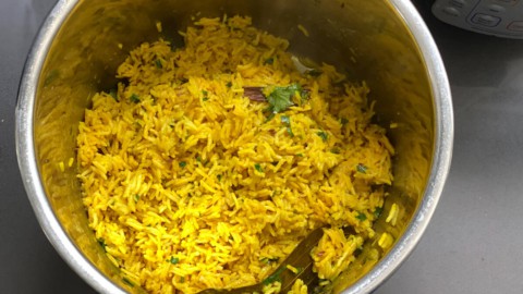 An instant pot with yellow rice fluffed after cooking.