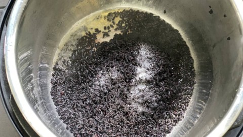 Adding black rice to the insert of your Instant pot.