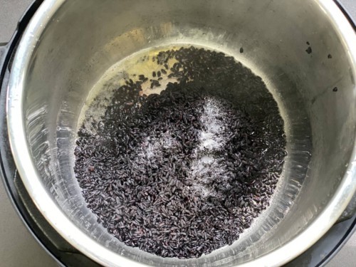 Adding black rice to the insert of your Instant pot.