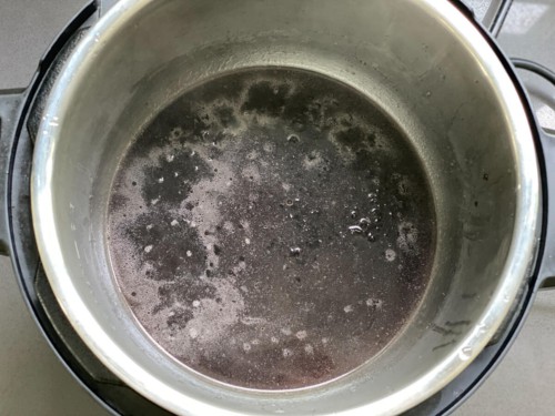 Adding water to an Instant Pot with black rice.