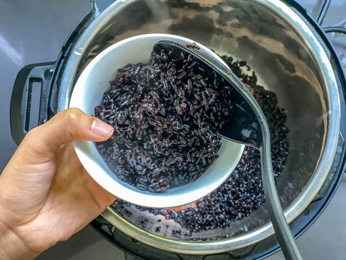 Scooping black rice from Instant Pot into a bowl
