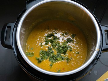 Adding lime juice and cilantro to Instant Pot dal.