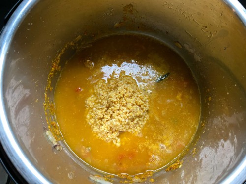 Adding water and dal to the insert of an Instant Pot