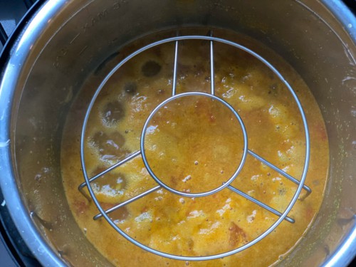 Placing a trivet over dal in an Instant Pot to make rice.