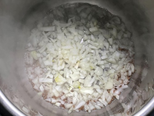 Onion added to the cumin seeds in the instant pot.