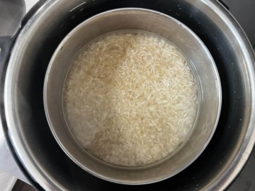 A bowl with rice and water on the trivet.