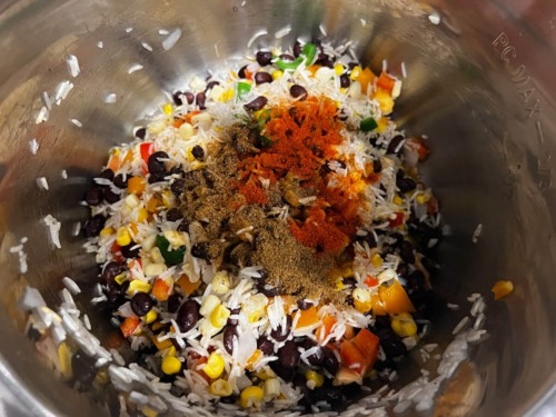 Adding rice, beans, peppers and spices to an Instant Pot.