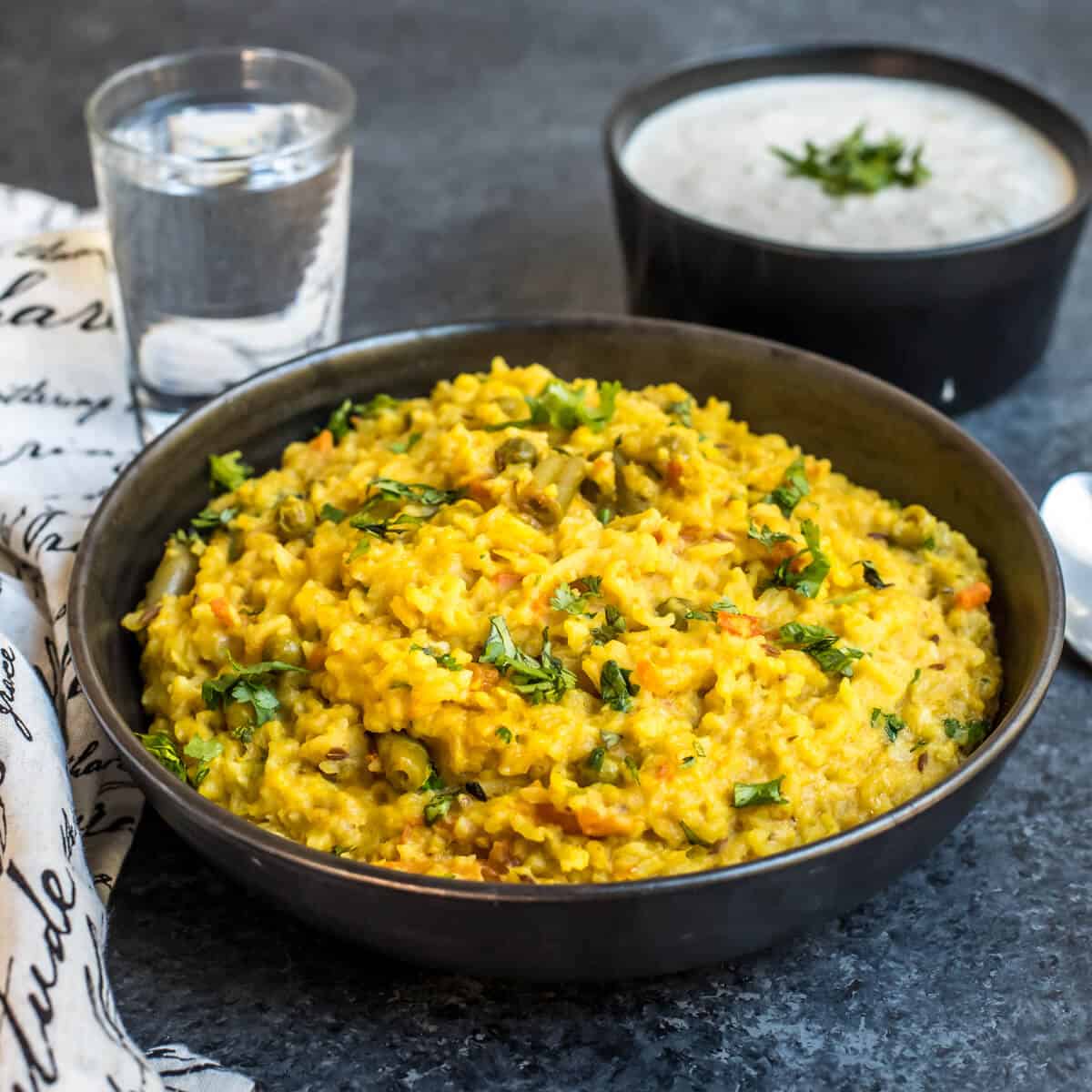 A bowl of Masala khichdi topped with cilantro leaves.