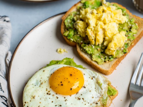 Two slices of toast topped with avocado and egg - one with a fried egg, another with scrambled eggs.