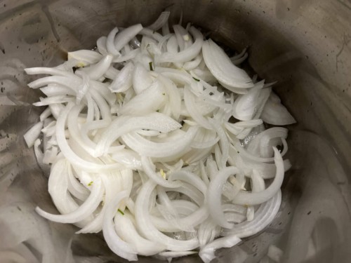 Sliced onions in the inner chamber of the Instant Pot.