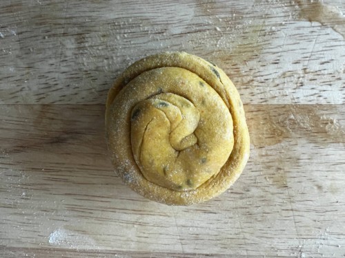 A fully coiled round of masala paratha dough.