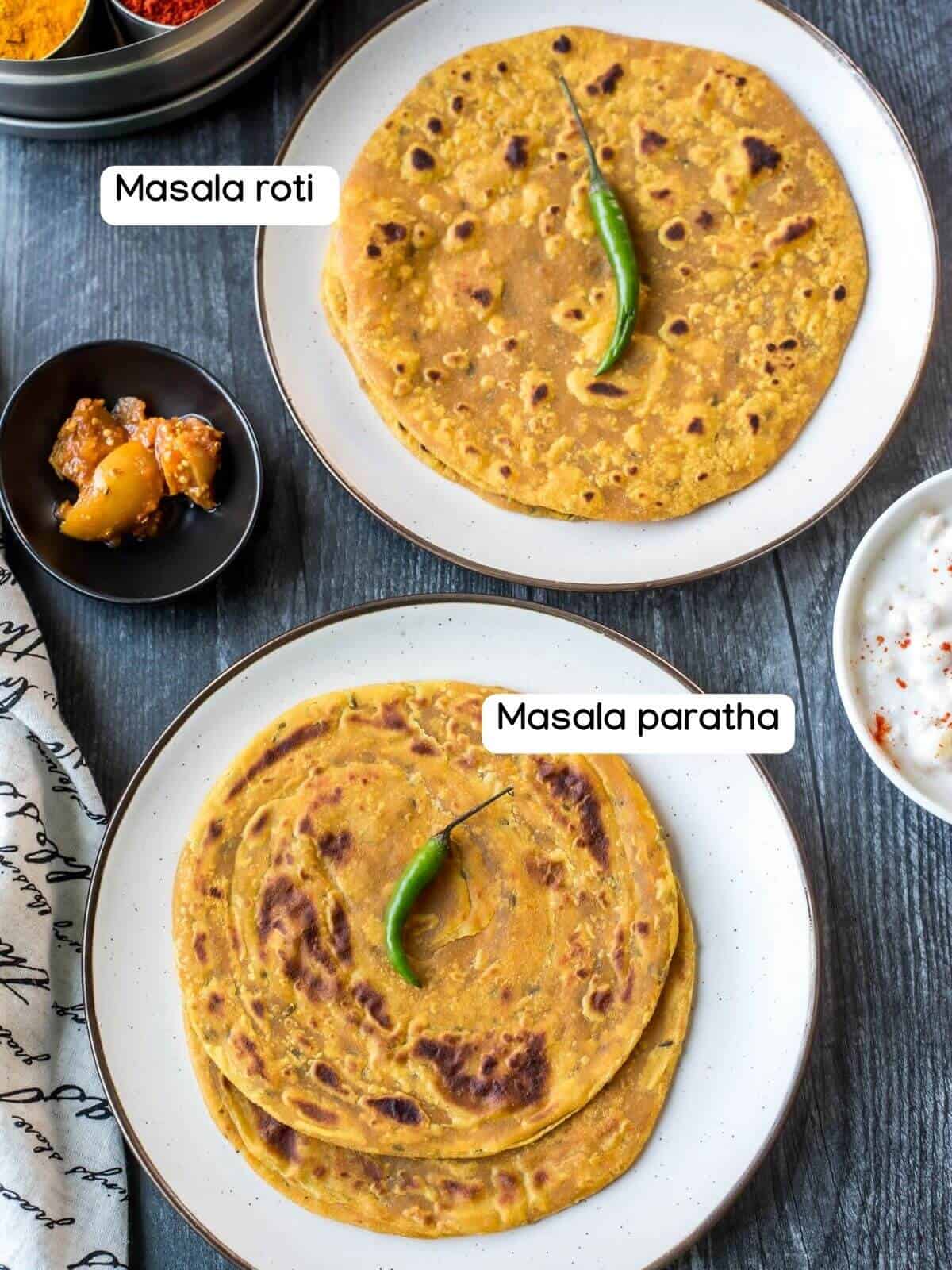 A top down photo of two white plate one with masala paratha in the front left and one with masala roti in the back right.