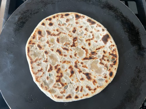 Cooking the other side of the paratha.