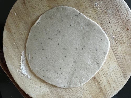 Rolling paratha dough into a circle.
