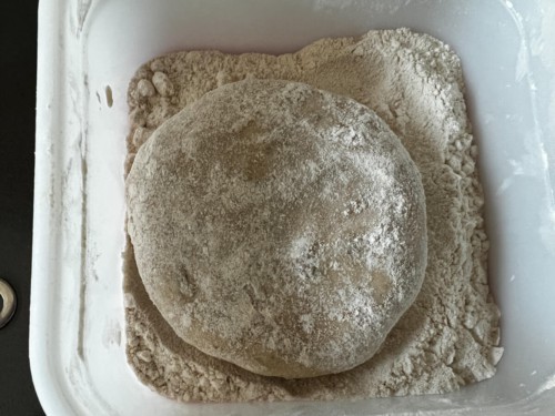 Covering paratha dough with flour.