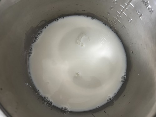 The inner pot of the Instant Pot with milk.