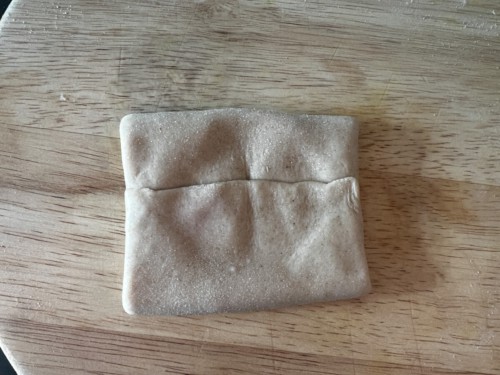 Bringing dough up to make a square shape.