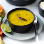 A bowl of trevti dal garnished with chilies.